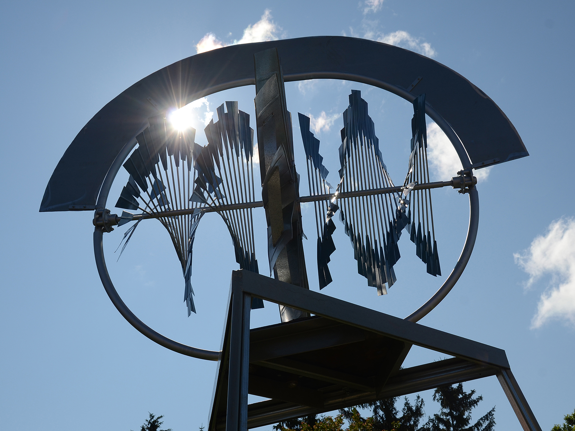 Gros plan sur un moulin à vent horizontal, dont les pales tournent en spirale sous l'effet du vent. Un ciel bleu et ensoleillé se trouve à l'arrière-plan.