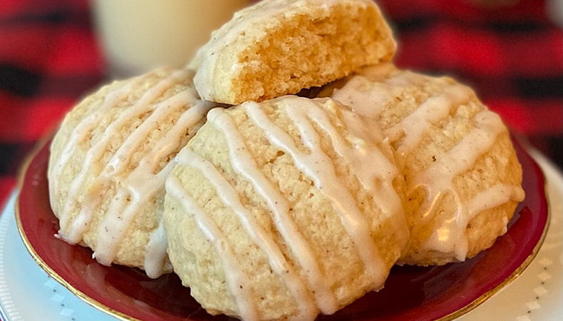 Des biscuits au lait de poule sur une assiette et un verre de lait de poule en arrière-plan