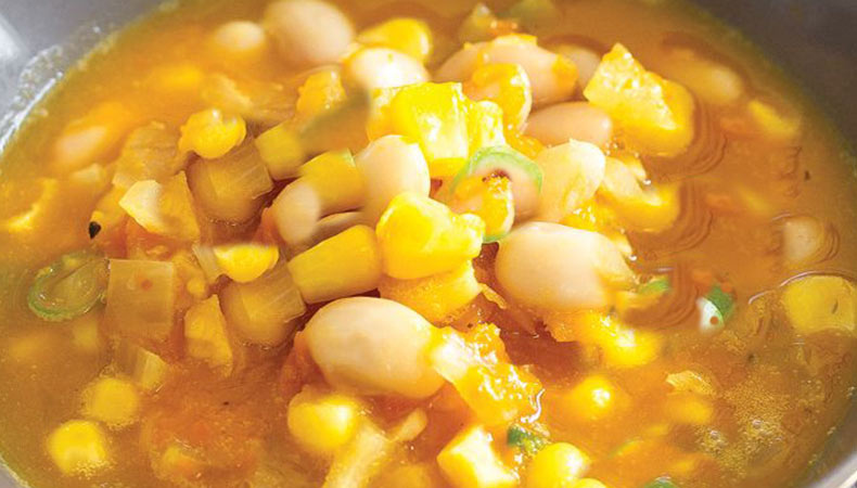 Closeup image of soup with corn and butternut squash