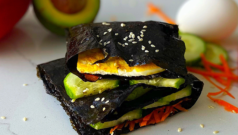 Two nori wraps are stacked on top of each other, on a white kitchen counter.