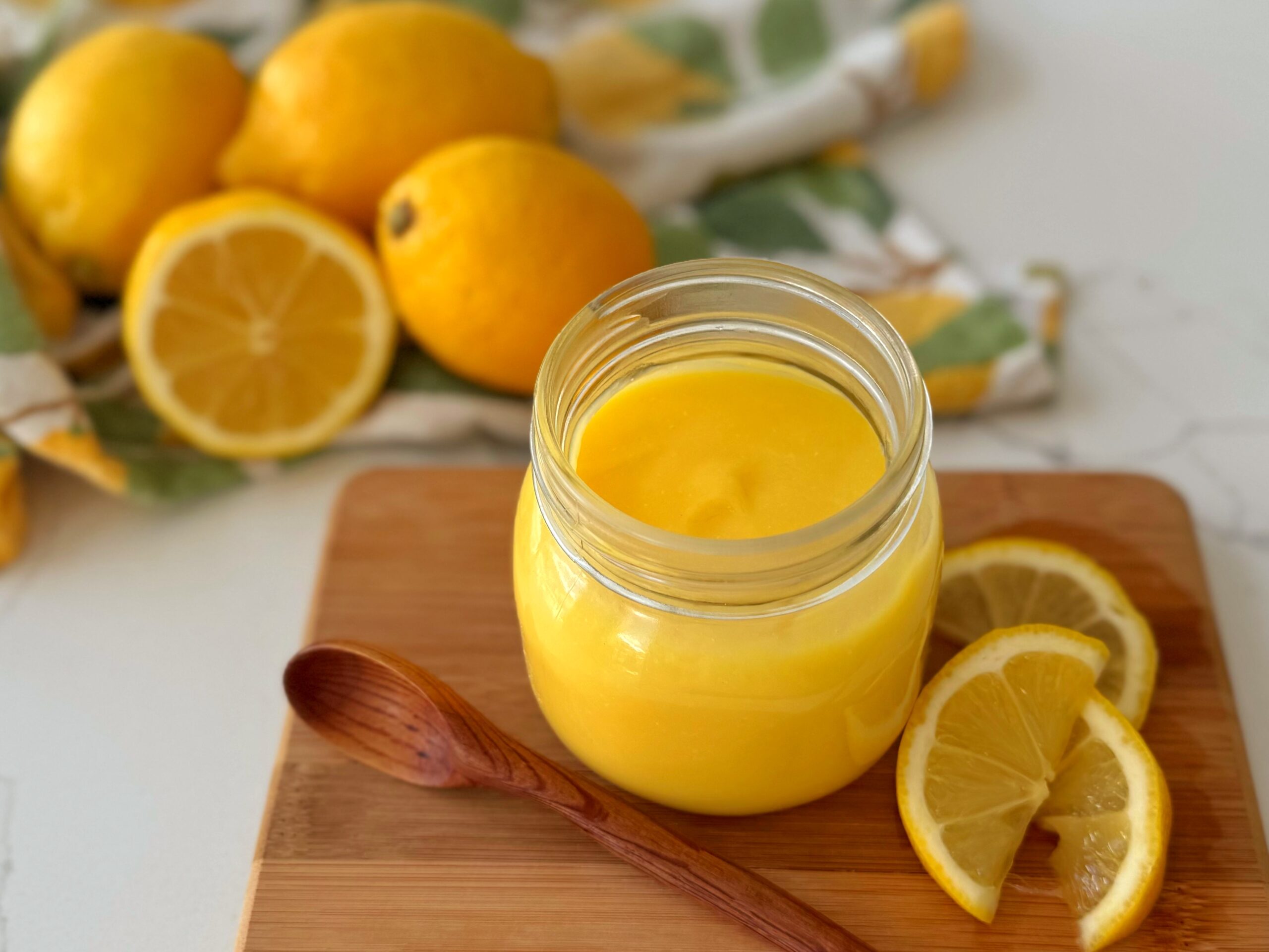 Pot de crème au citron sur une planche en bois