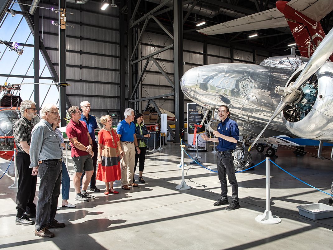 A guide offers a tour to a group of people in the museum's Reserve Hangar