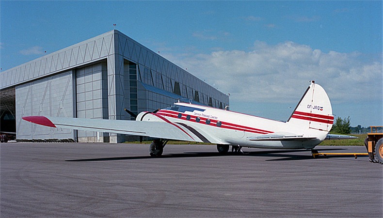 White Boeing 247-D aircraft parked on the tarmac outdoors in front of the museum.