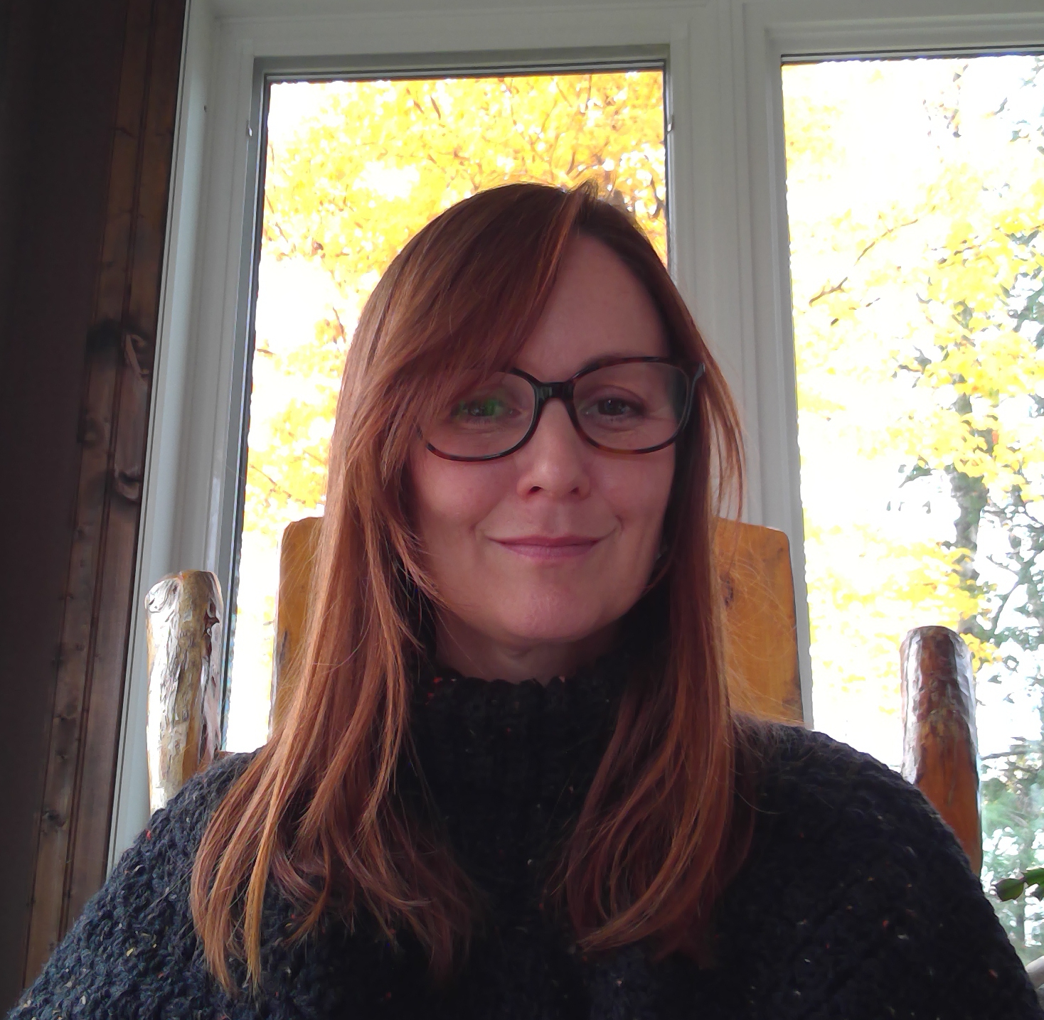 Headshot of a person with long brown hair an glasses