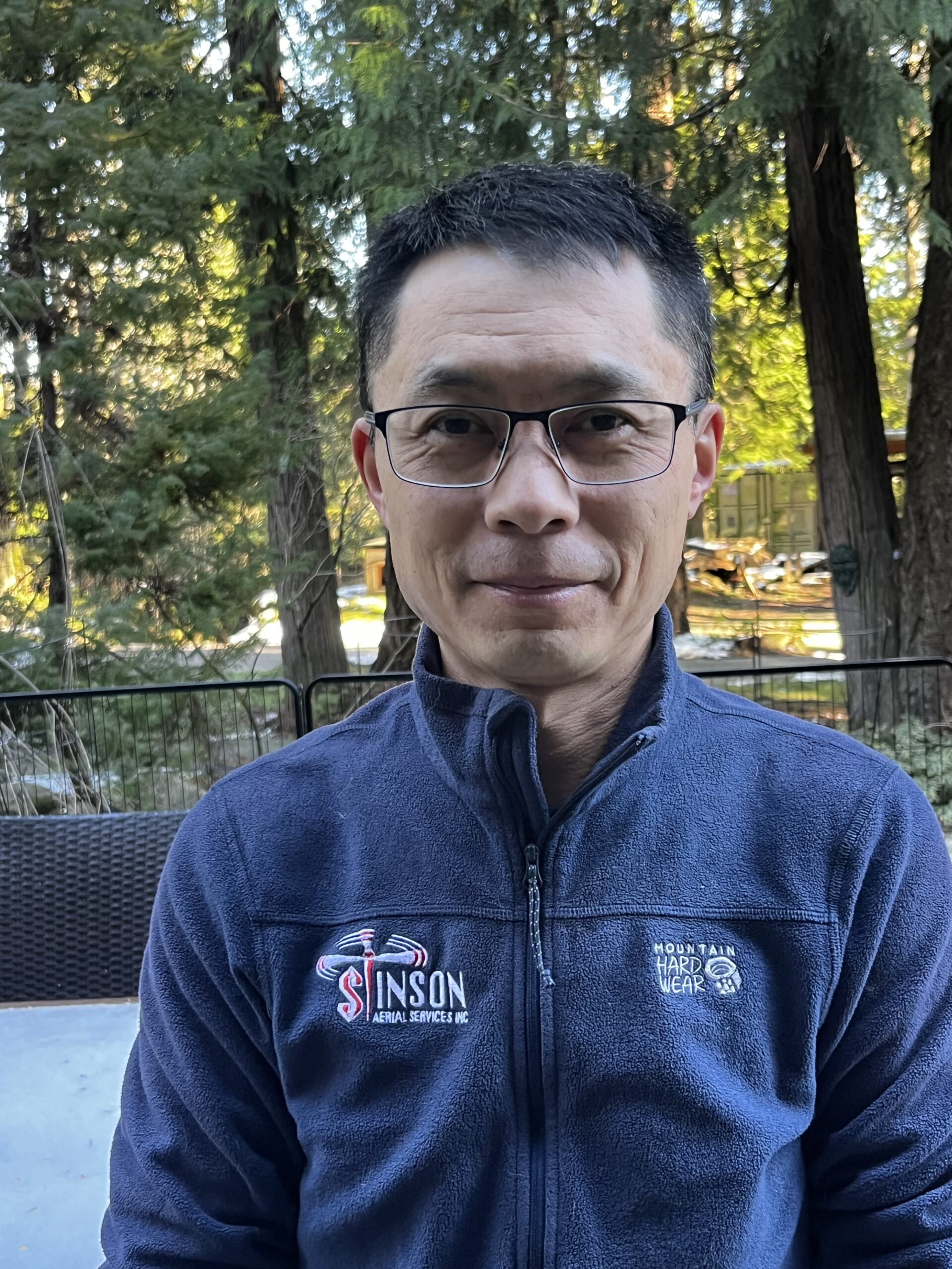 Smiling photo of a man with short black hair and glasses