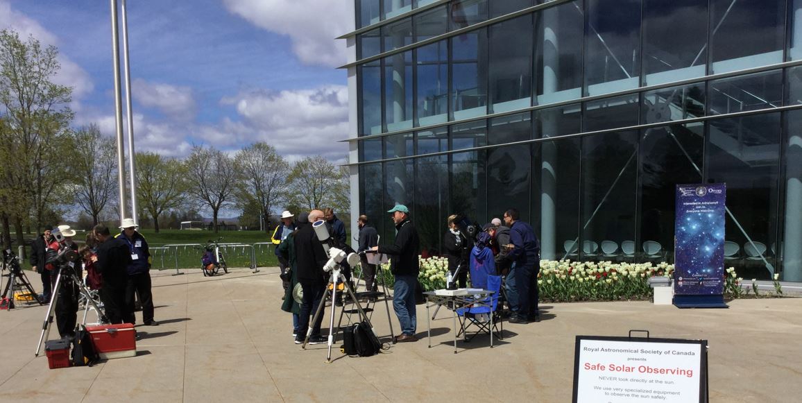 People using telescopes in front of the museum