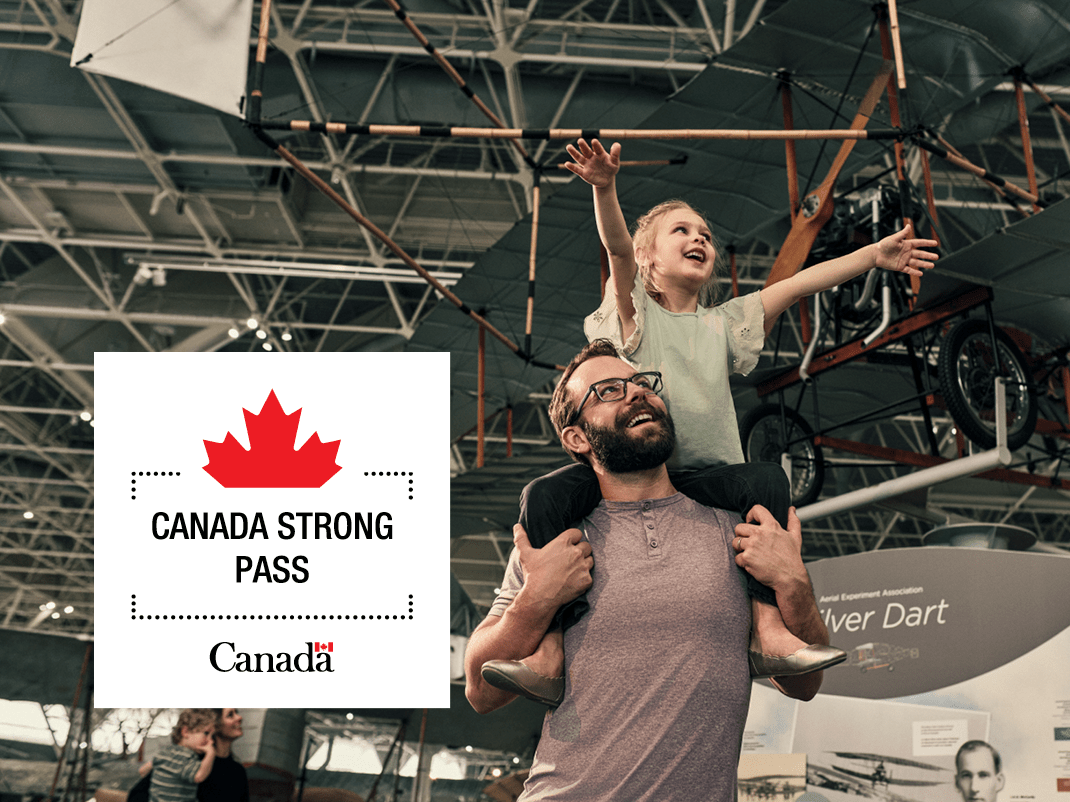 A young child sits on the shoulders of an adult in the museum with arms held high. A logo with a half maple leaf and the words Canada Strong Pass and Canada appear.