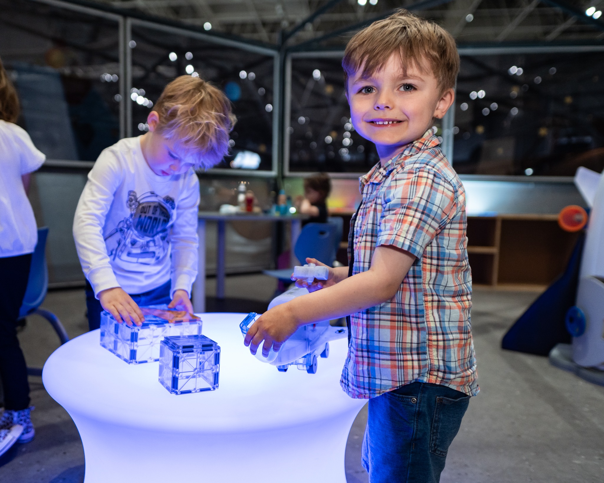 Two small children play with space toys in the museum's Exploration Station studio.