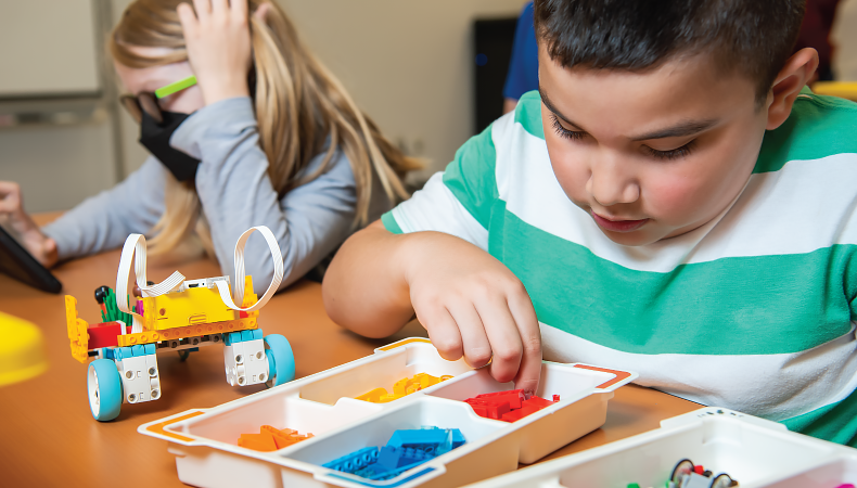 Two children work with building materials.