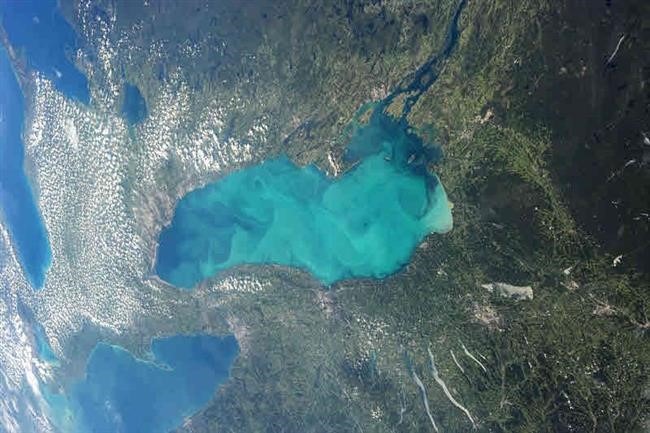Image de la Terre vue de l'espace, montrant des terres vertes entourant une eau bleu turquoise au centre.