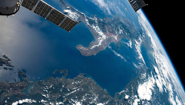 La planète Terre vue de l'espace proche. Un satellite est visible dans le coin de la photo.