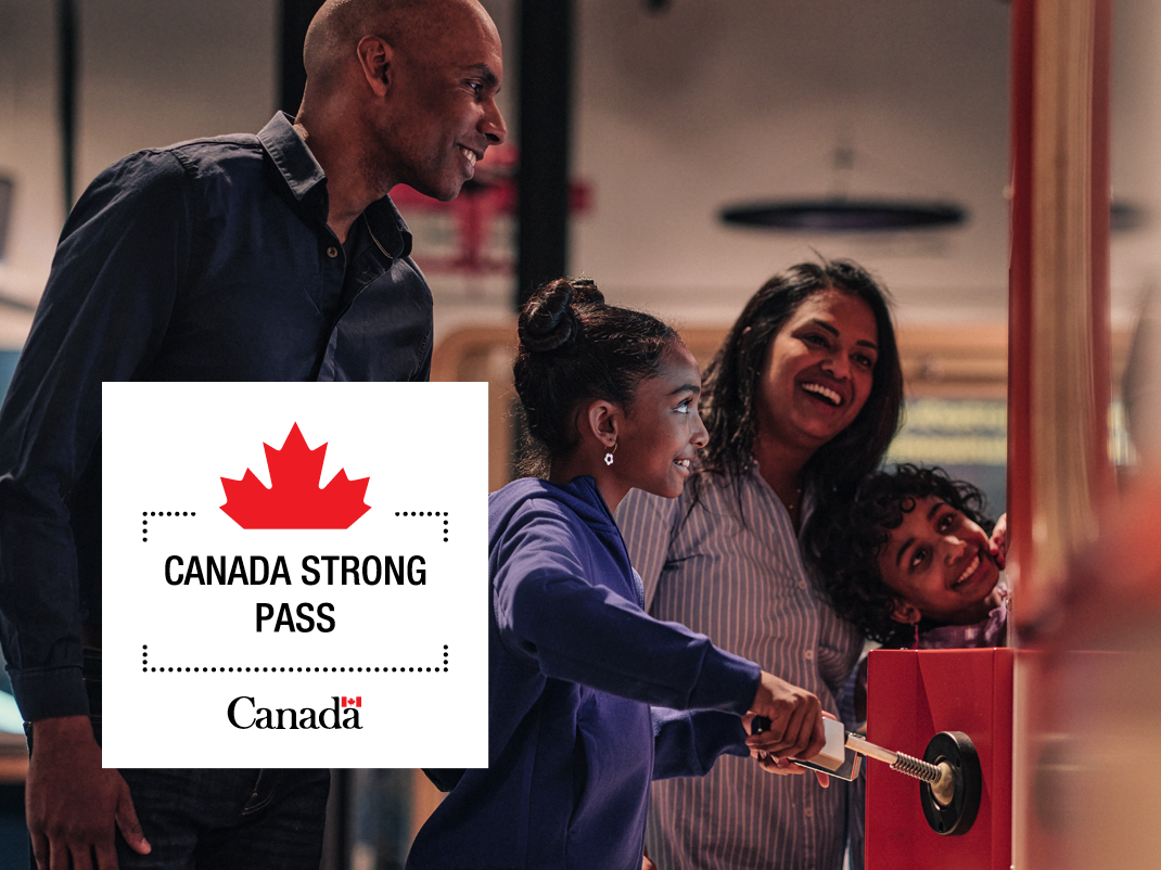 A family of four interacts with a hands-on exhibit at a science museum. A young girl turns a crank while her parents and younger sibling smile and watch. In the bottom left hand corner there is a white box and inside it has a Canada maple leaf and the Government of Canada symbol and it says "Canada Strong Pass"