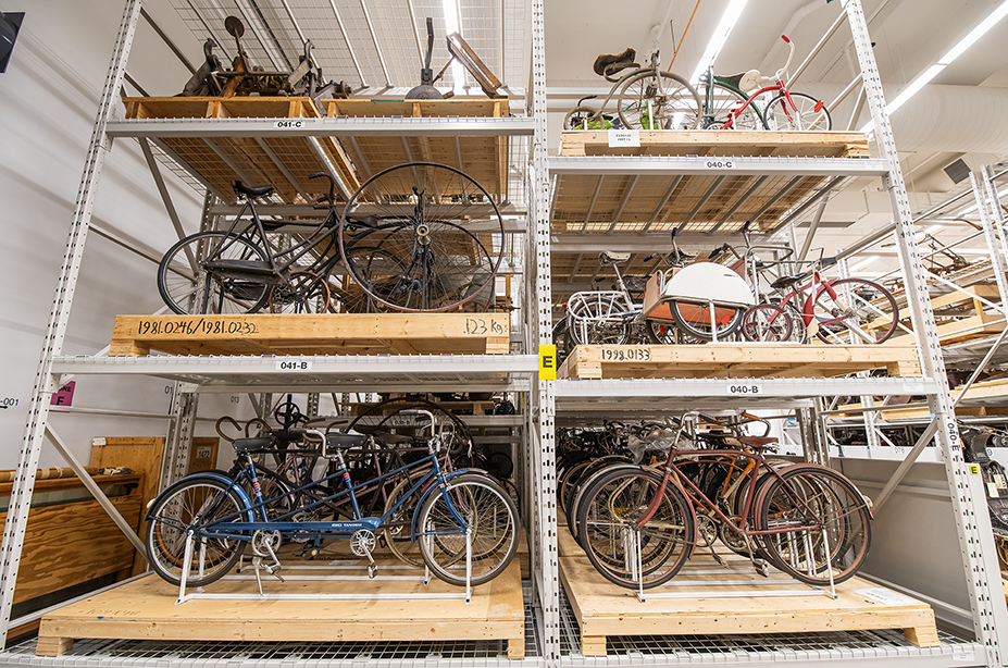 A collection room with shelves of bicycles.