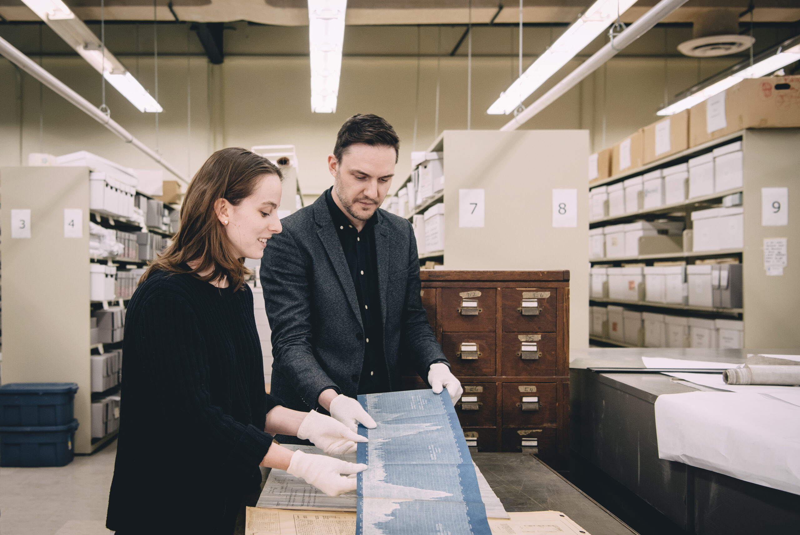 Cristina Wood, candidate à la maîtrise, et Tom Everrett, conservateur, examinent des documents historiques dans les archives du musée