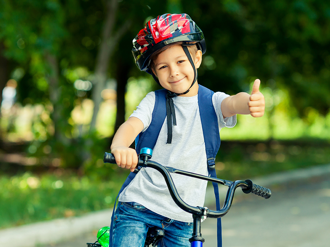 Un enfant porte un casque lorsqu'il fait du vélo en plein air.